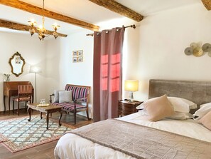 Une chambre à coucher comprenant un lit, un bureau, une chaise, une lampe et un ventilateur de plafond.