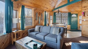 Un interno accogliente con soffitto in legno, un divano, un tavolo da pranzo e una ventola a soffitto.