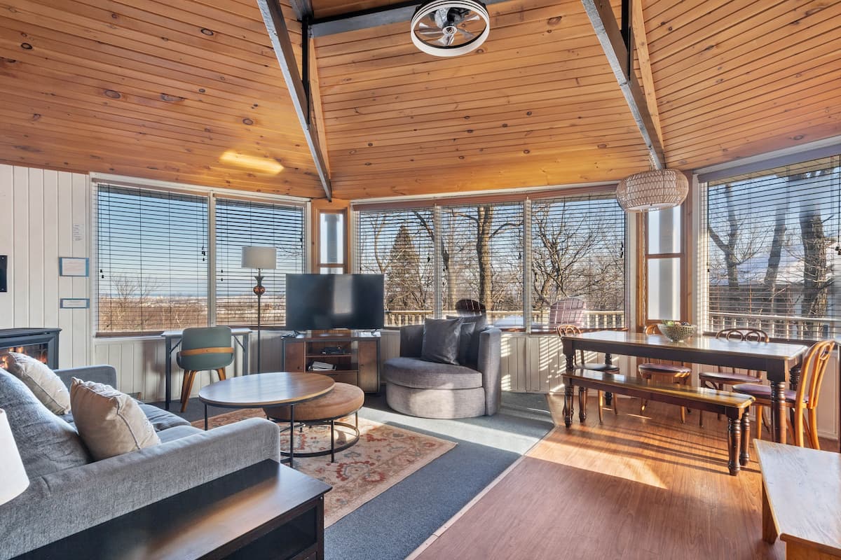 A spacious living area with a fireplace, a television, a dining table, and a sofa.
