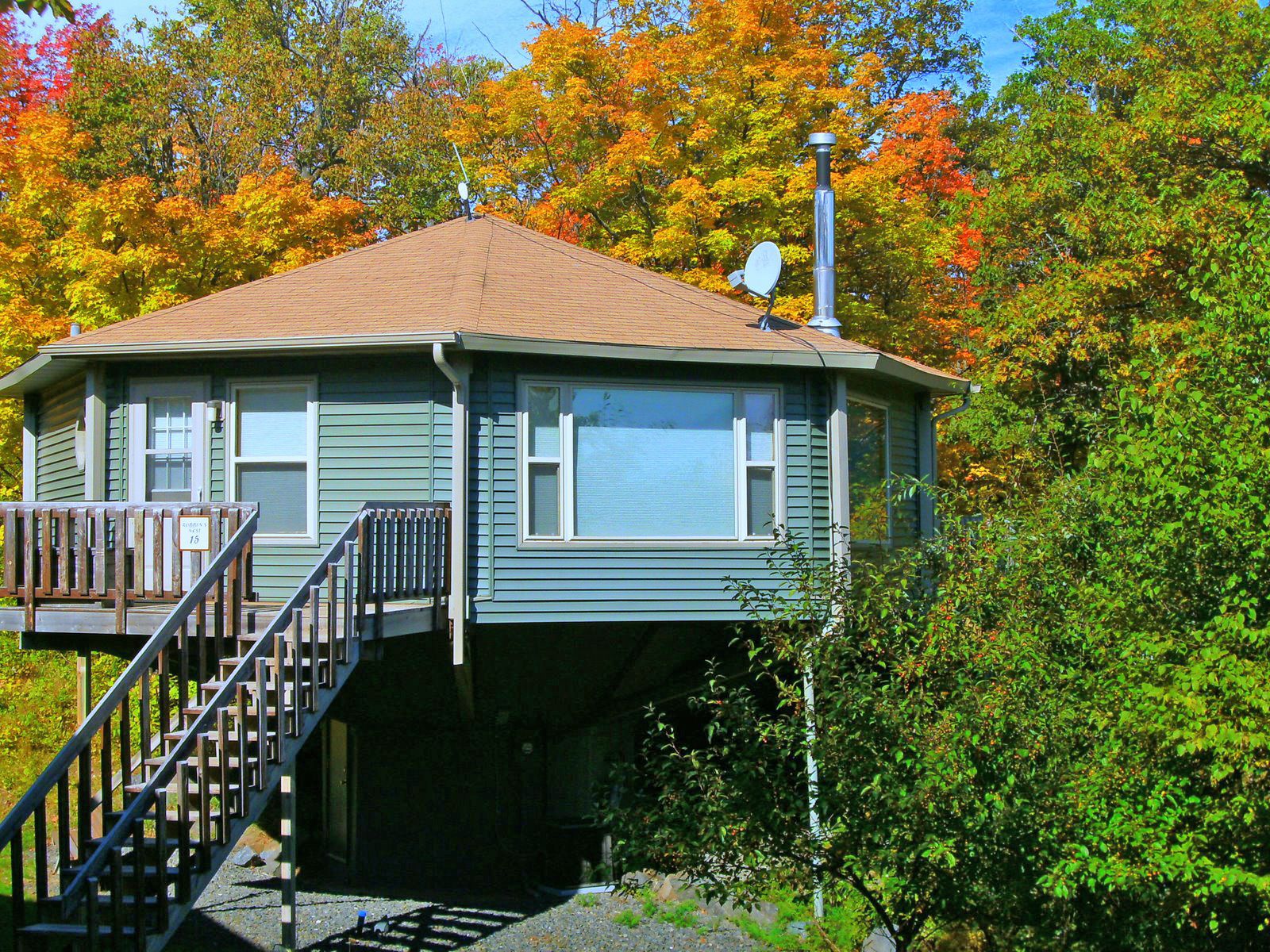 A house with a small deck and stairs leading up to the entrance.
