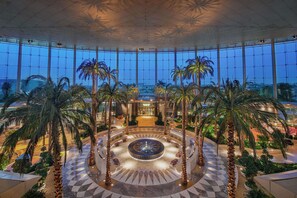 A spacious atrium with a central fountain, surrounded by palm trees and a checkered floor pattern. - Waldorf Astoria Cairo Heliopolis (Cairo)