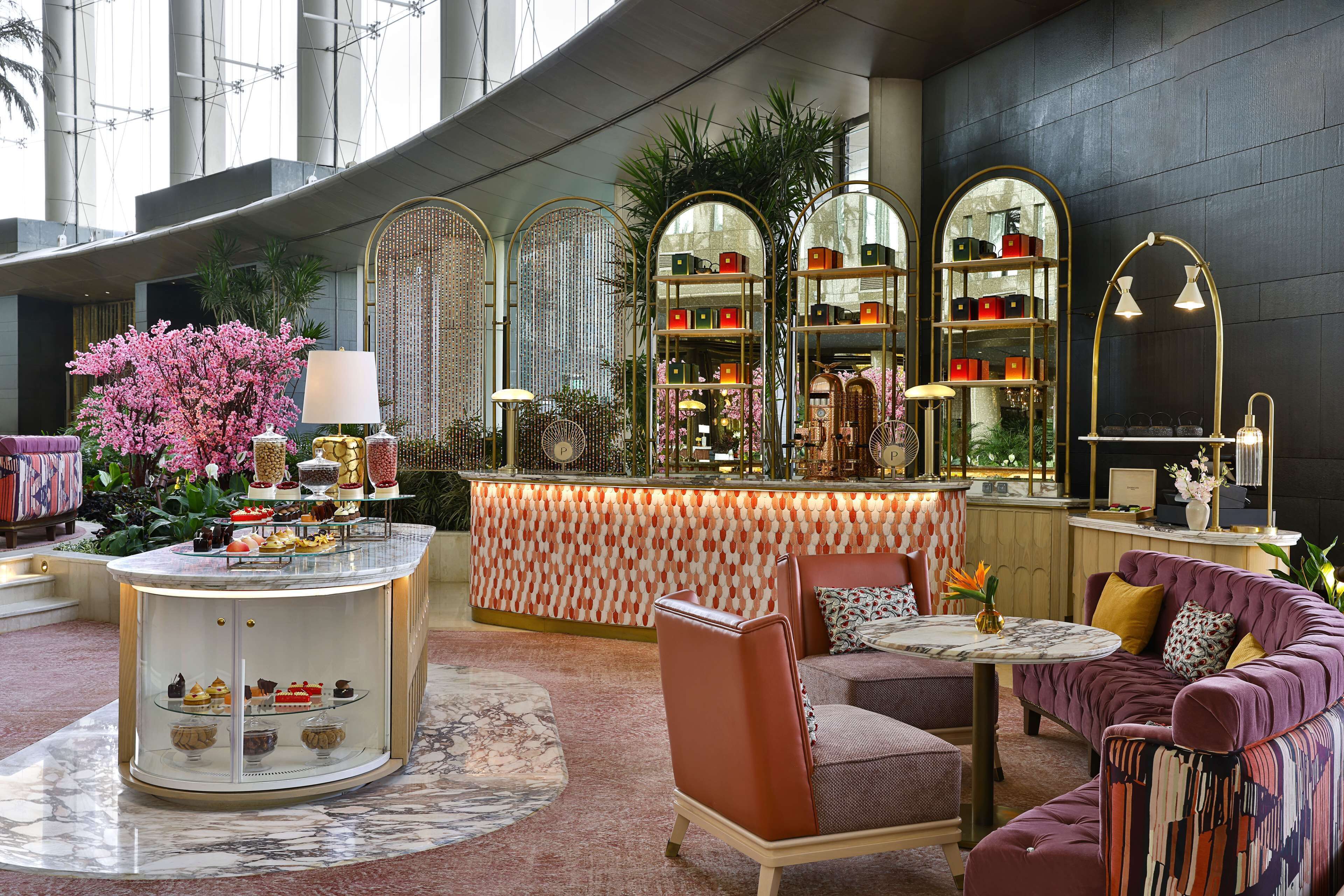 A luxurious lobby with a central bar area, seating arrangements, and decorative elements.