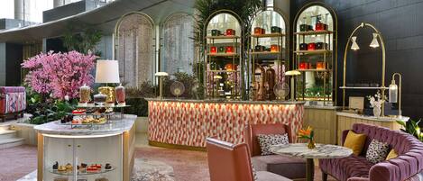 A luxurious lobby with a central bar area, seating arrangements, and decorative elements.