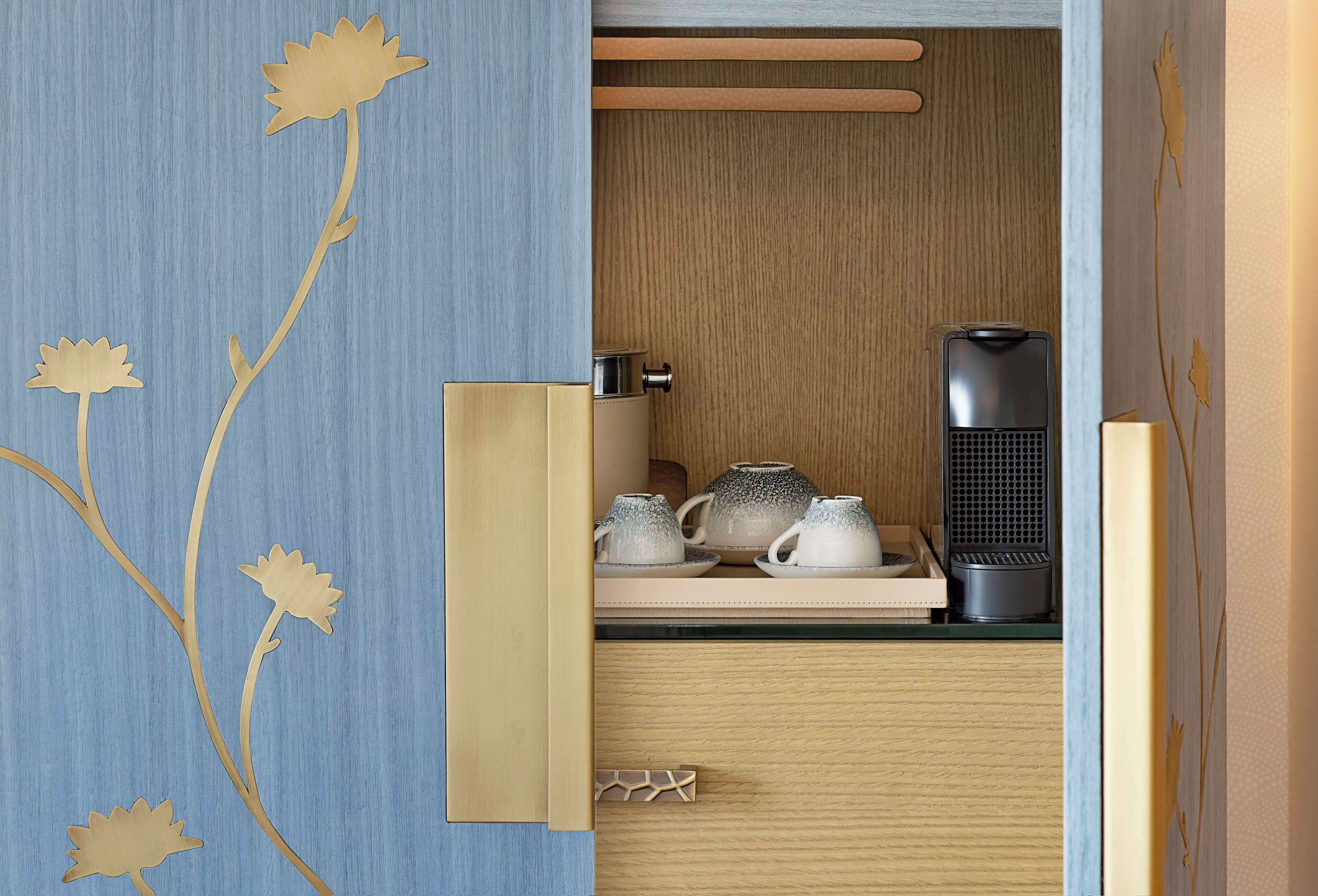 A kitchen with wooden cabinets, a coffee maker, and a kettle on the counter.