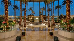 A spacious lobby with palm trees, a central fountain, and seating areas. - Waldorf Astoria Cairo Heliopolis (Cairo)