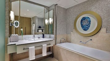 Ein modernes Badezimmer mit einem großen Spiegel, zwei Waschbecken, einer Badewanne und einem Handtuchhalter.