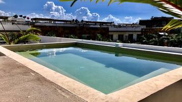 Een buitenzwembad en ligstoelen