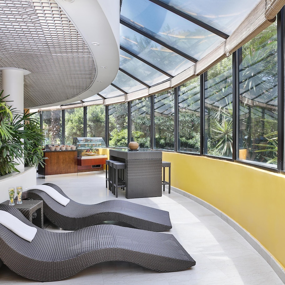 A modern interior with curved seating, a central table, and large windows.