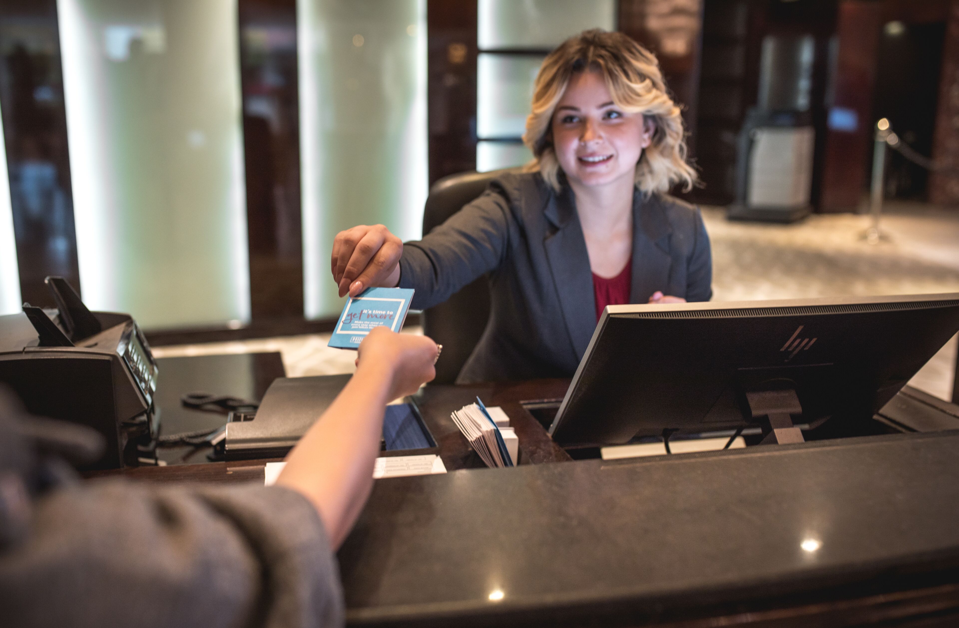 A reception desk with a laptop, a phone, and a card reader.