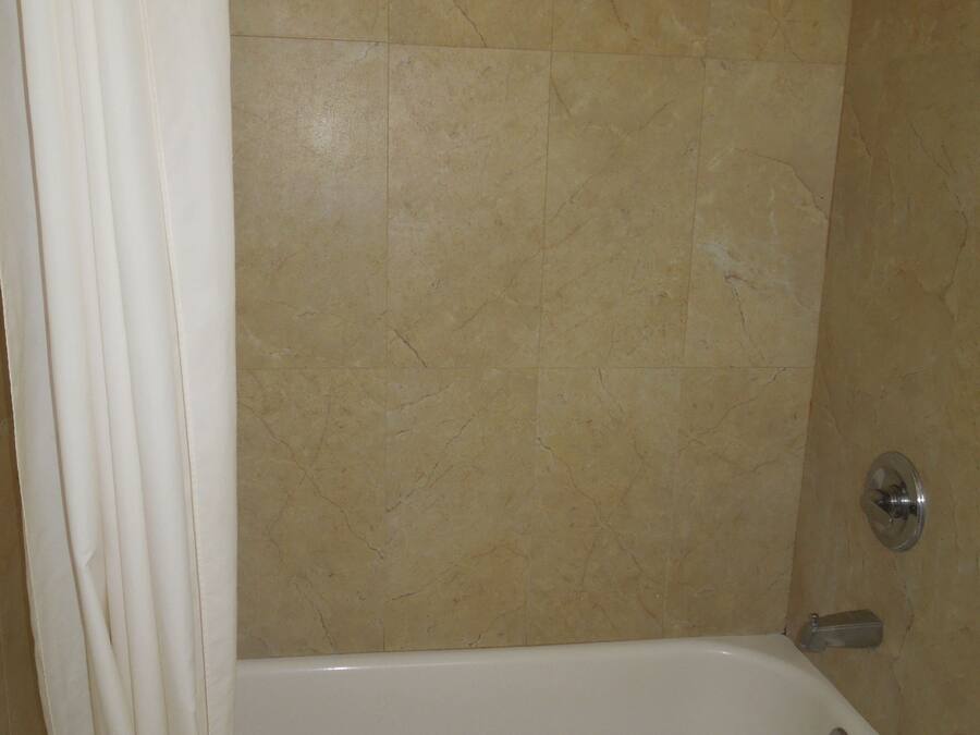 Un baño con bañera, ducha y cortina.