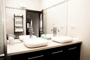 A modern bathroom with two sinks, a glass, a towel rack, and a mirror. - Panoramic Ocean View 1 min From the Sea (Tel Aviv)