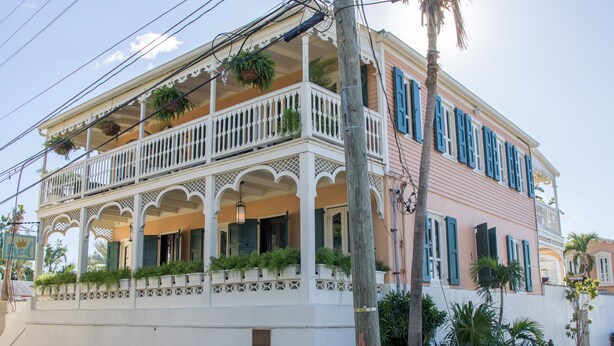 A two-story building with a balcony, white railings, and green shutters. - The Fred - Adults Only (Frederiksted)