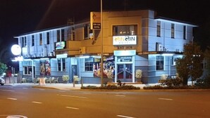 Un hotel con un cartel que reza 'EINLIN HOTEL EST 1878' y 'AIRE ACONDICIONADO', indicando sus servicios.