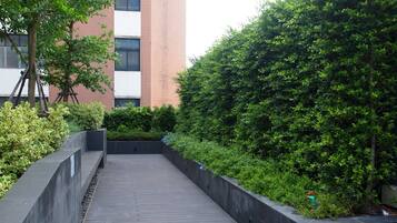 Un sendero bordeado de vegetación y un edificio moderno.