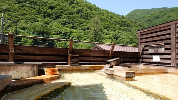 A hot spring area with wooden structures and a wooden fence. - Nakaya Ryokan (Minakami)