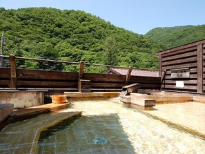 A hot spring area with wooden structures and a wooden fence. - Nakaya Ryokan (Minakami)