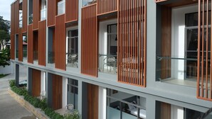 Um edifício moderno com várias varandas, janelas grandes e um design contemporâneo e sóbrio.