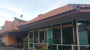 A building with a tiled roof, large windows, and a signboard. - Rim Khuan Resort (Khuan Khanun)