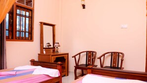 A hotel room with two beds, a wooden dresser, a chair, and a window with bars. - The cool nest yala hotel (Thissamaharama)