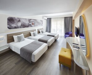 Habitación de hotel con dos camas, un escritorio, una silla, un espejo grande y una obra de arte en la pared.