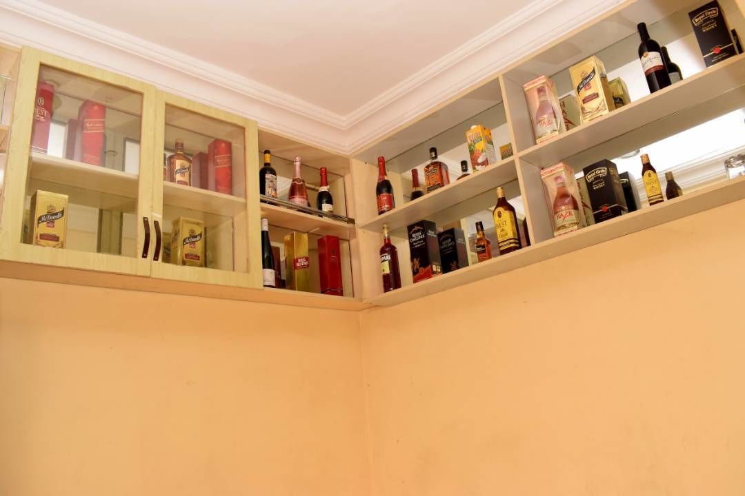 A corner of a room with shelves containing various bottles and boxes, likely a liquor store or bar.