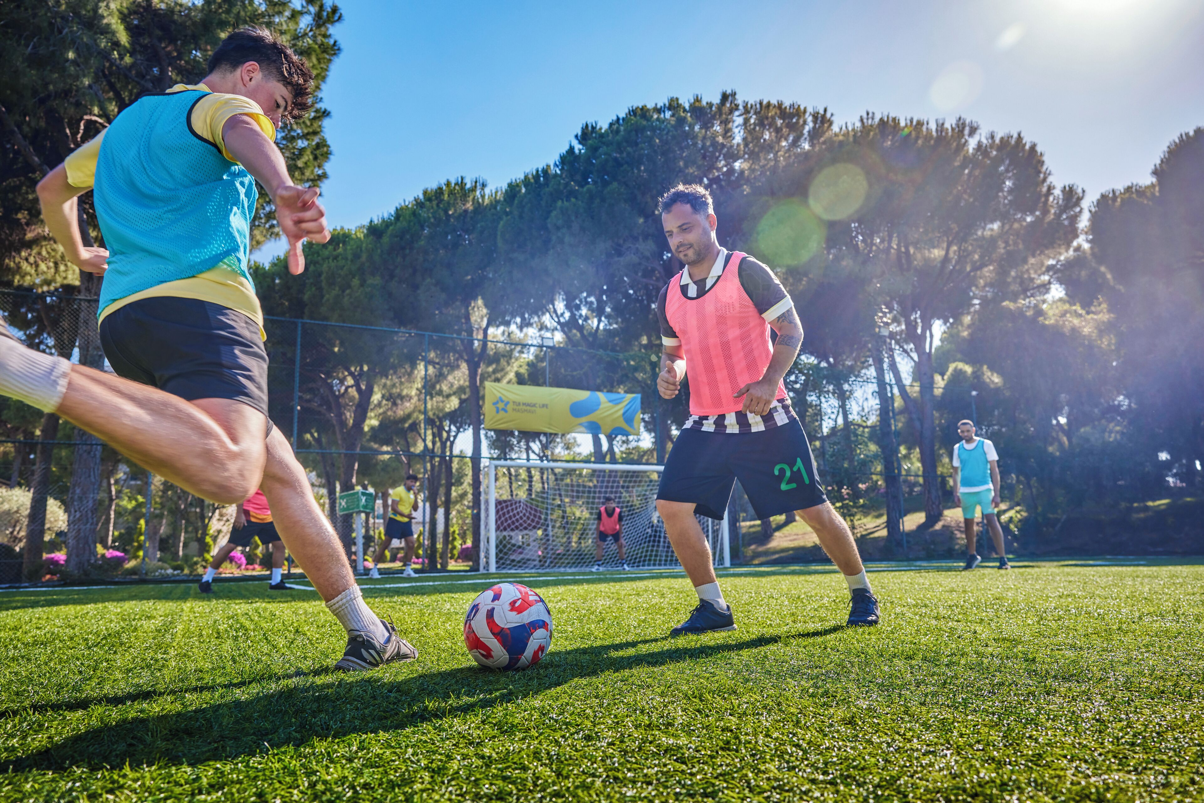 A soccer game on a grassy field with players in sports attire.