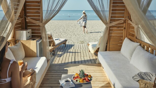 A wooden deck with a sofa and a table with a fruit bowl and a cup of coffee. - TUI MAGIC LIFE Masmavi - All inclusive (Serik)