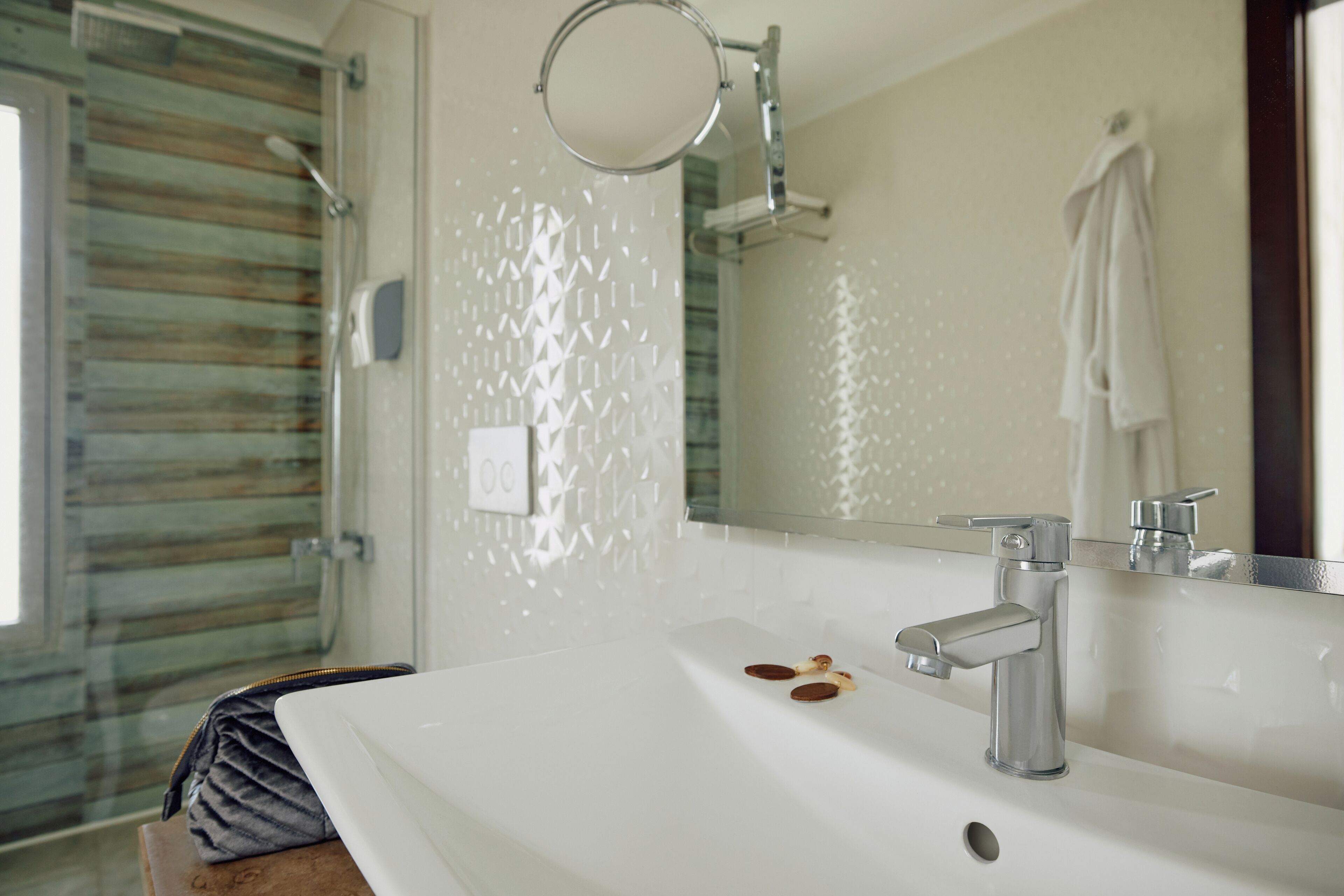 A bathroom with a white sink, a mirror, and a towel rack.