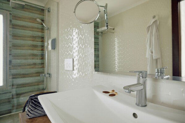 A bathroom with a white sink, a mirror, and a towel rack.