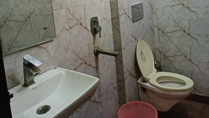 Un bagno con lavandino, WC e specchio.