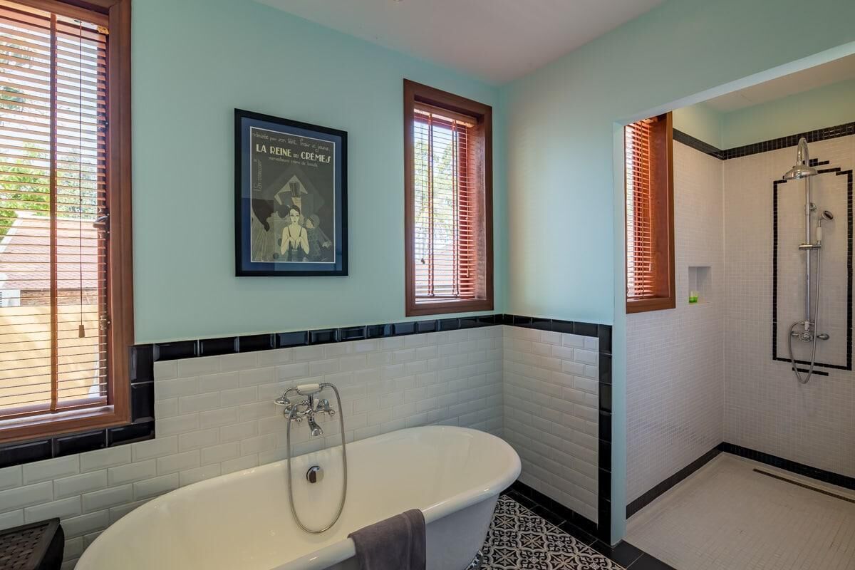 Une salle de bain avec une baignoire sur pieds, un espace douche et une affiche encadrée au mur.