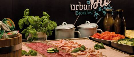 A breakfast buffet with various meats, vegetables, and a sign that reads "urban breakfast."