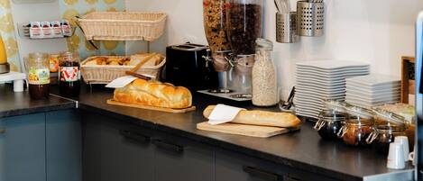 Une cuisine équipée d’un four à micro-ondes, d’un grille-pain et de divers aliments disposés sur le plan de travail.