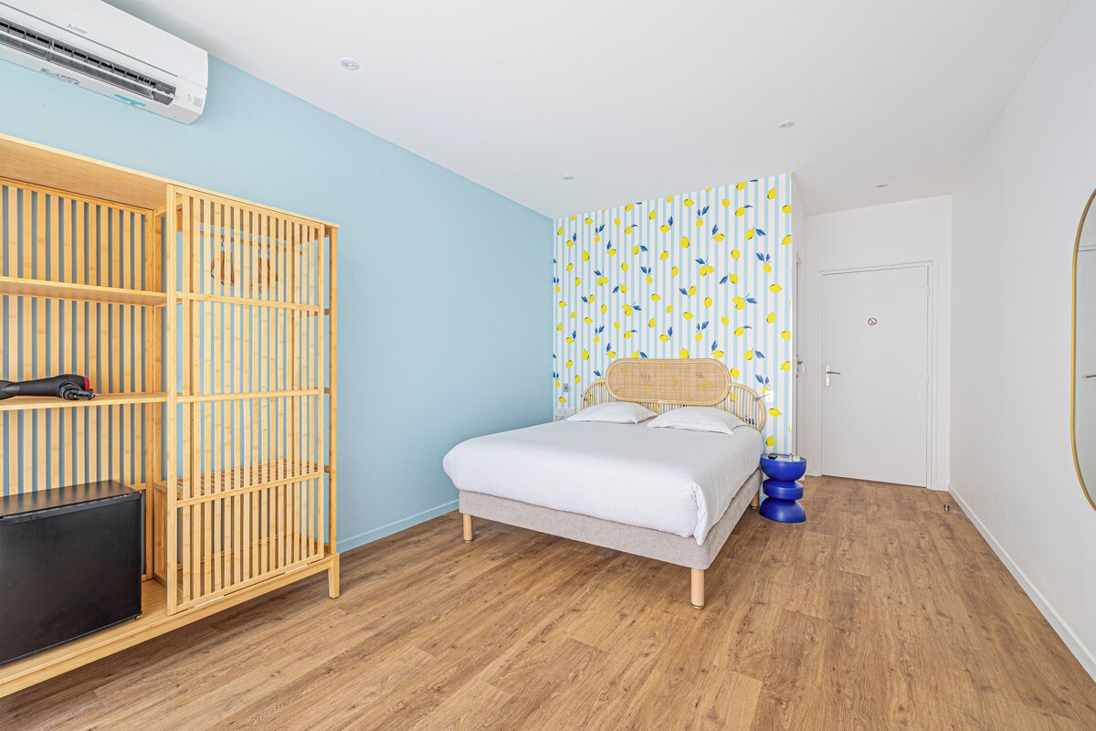 Un dormitorio con cama, armario, espejo y pared con diseño.