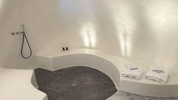 A modern bathroom with a freestanding bathtub, a showerhead, and a towel rack.