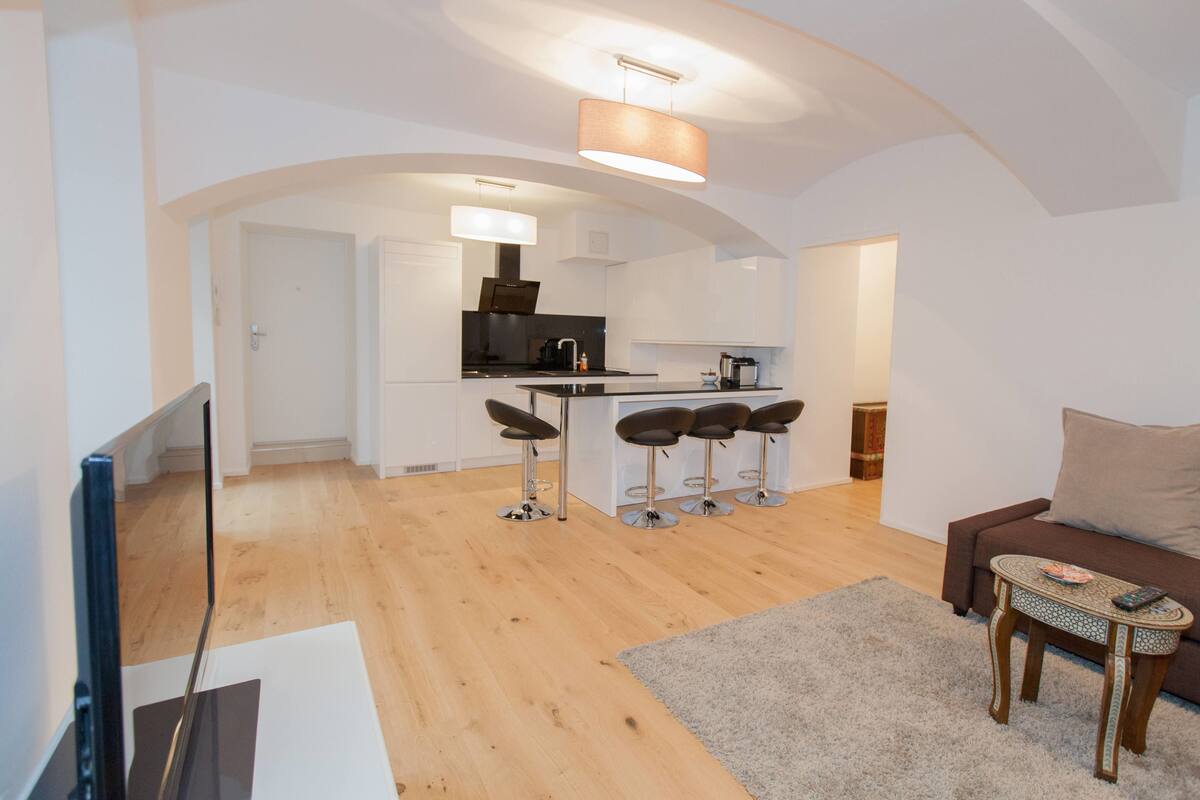 A modern apartment with a kitchen, dining area, and living room.