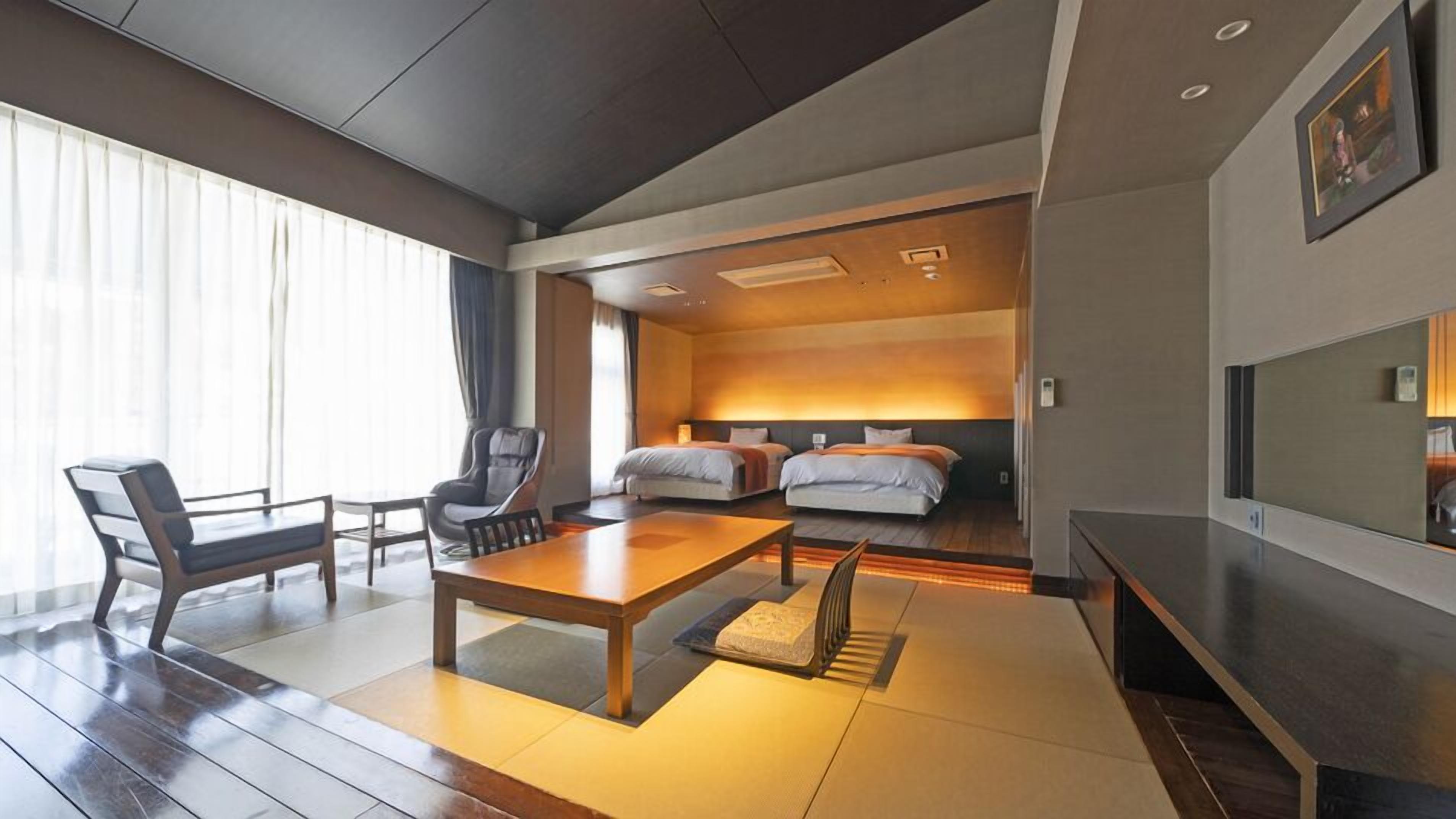 Une chambre d’hôtel moderne avec un plancher en bois, une table à manger, deux lits, un téléviseur et une grande fenêtre avec des rideaux.