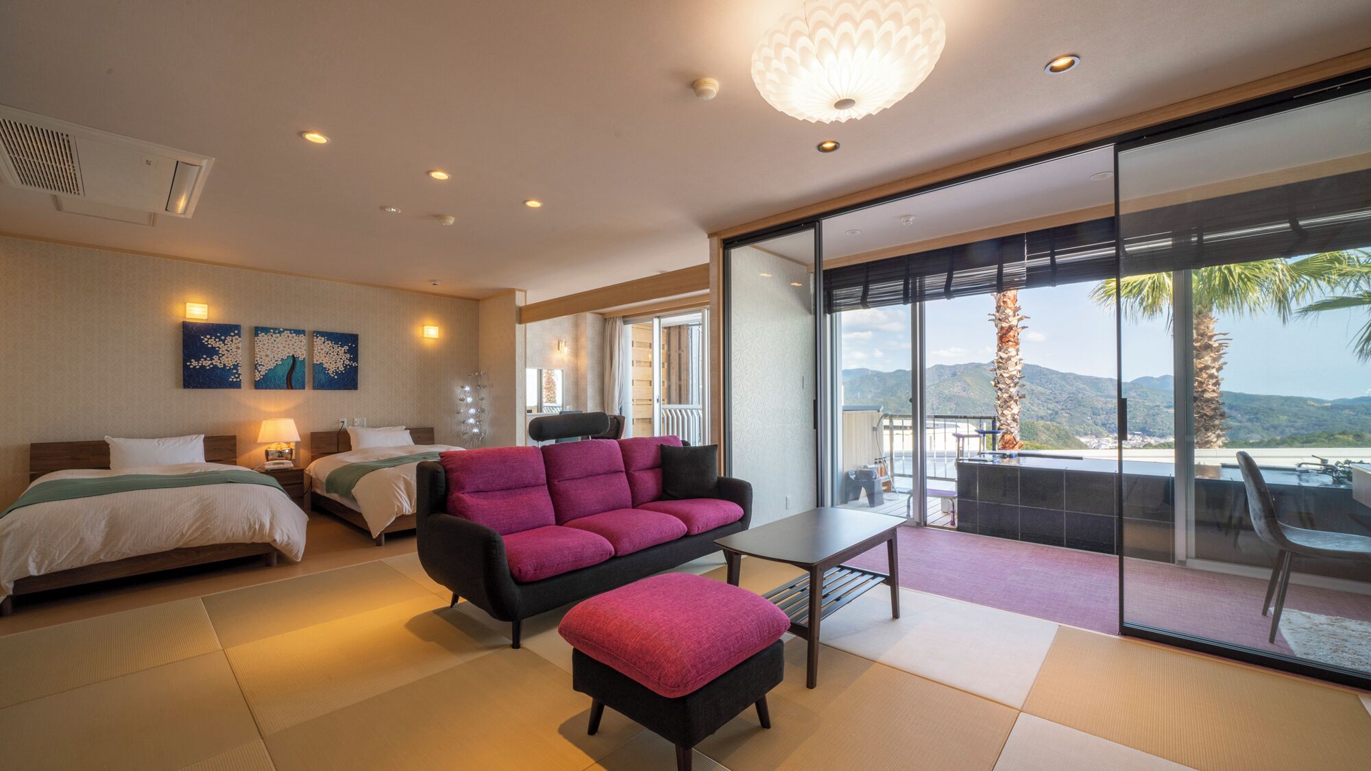 Une chambre d’hôtel avec un lit, un canapé, une table et un balcon offrant une vue sur les montagnes.