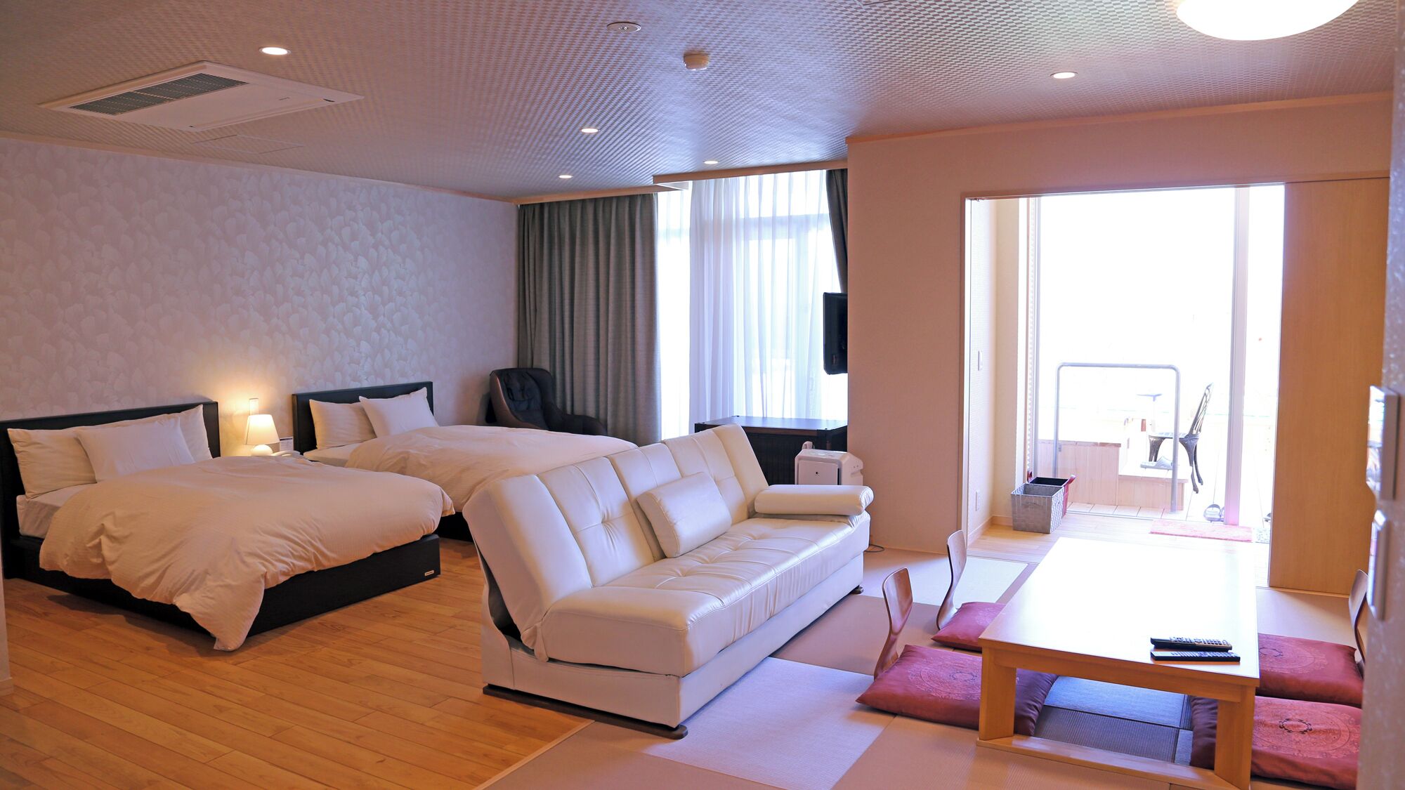 Une chambre d’hôtel avec un grand lit, un canapé, une table à manger et une vue sur l’extérieur.