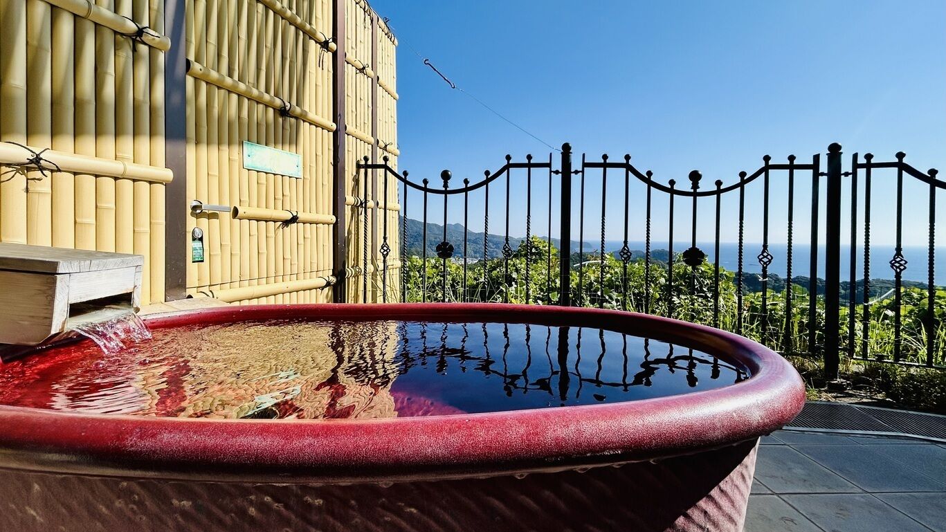 A hot tub with a clear view of the surrounding bamboo structure and a metal fence.
