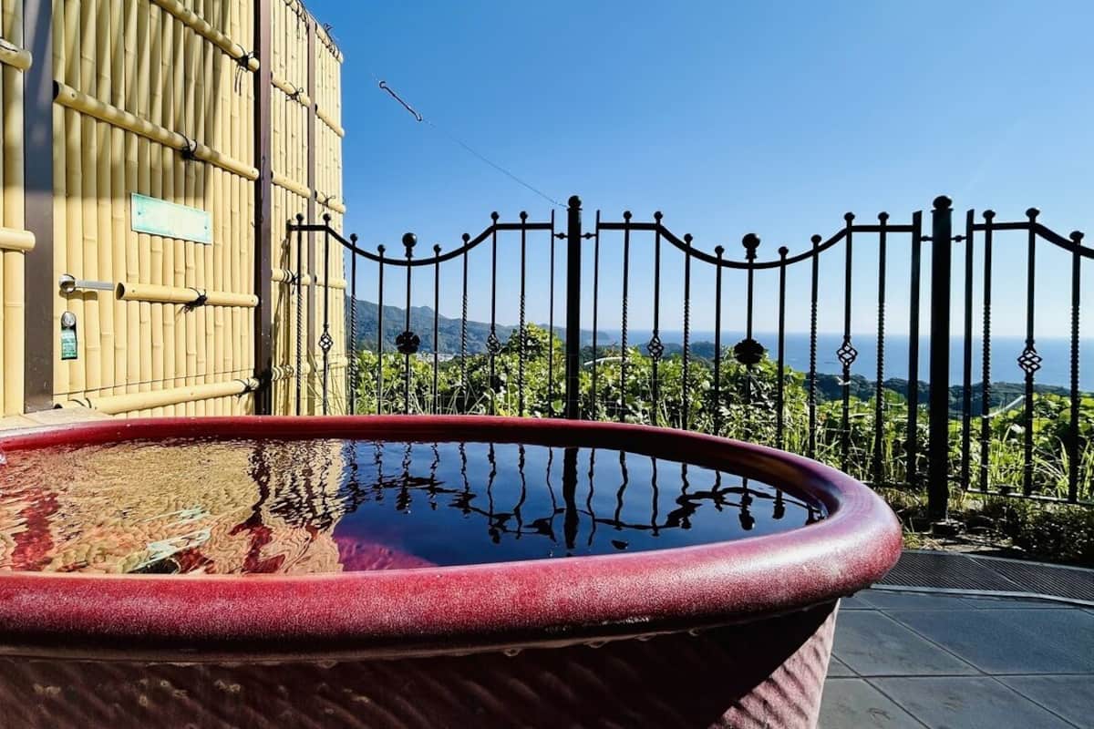 A hot tub with a clear view of the surrounding bamboo structure and a metal fence.