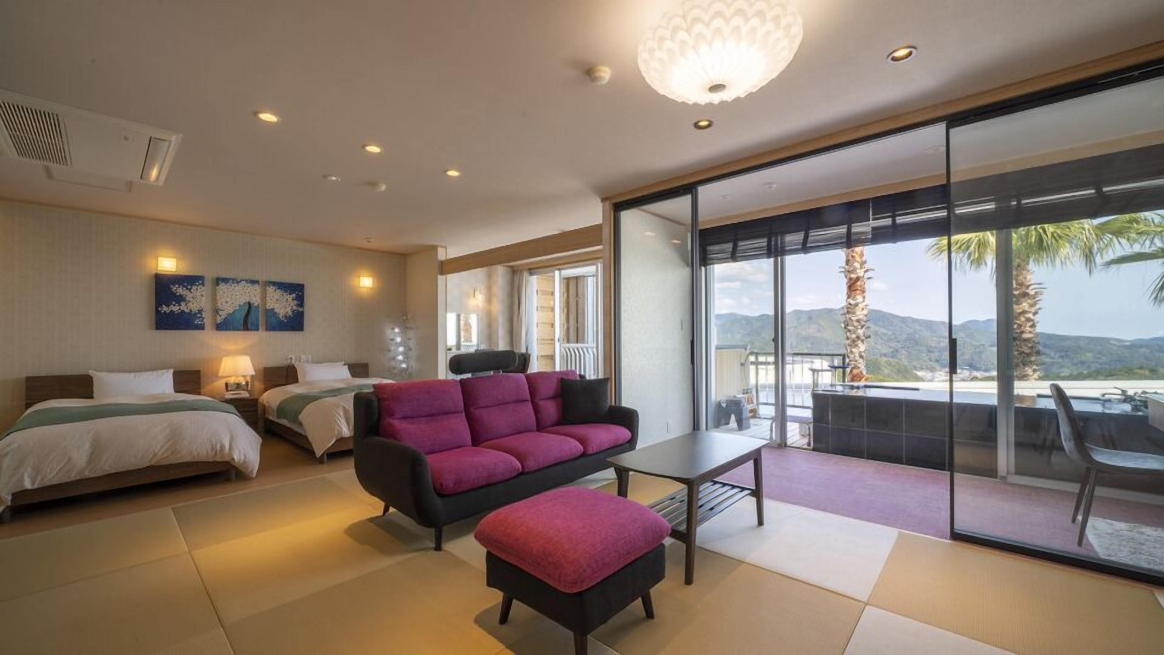 Une chambre d’hôtel moderne avec un lit, un canapé et un balcon offrant une vue sur les montagnes.