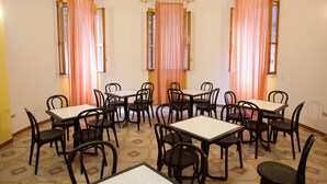 Un espace repas comprenant plusieurs tables et chaises, disposées en cercle autour d’un espace central ouvert.