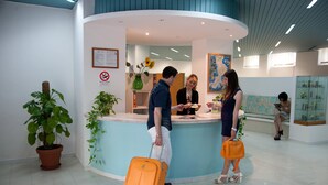 Een receptiezone met een balie, kamerplanten en een kaart aan de muur.