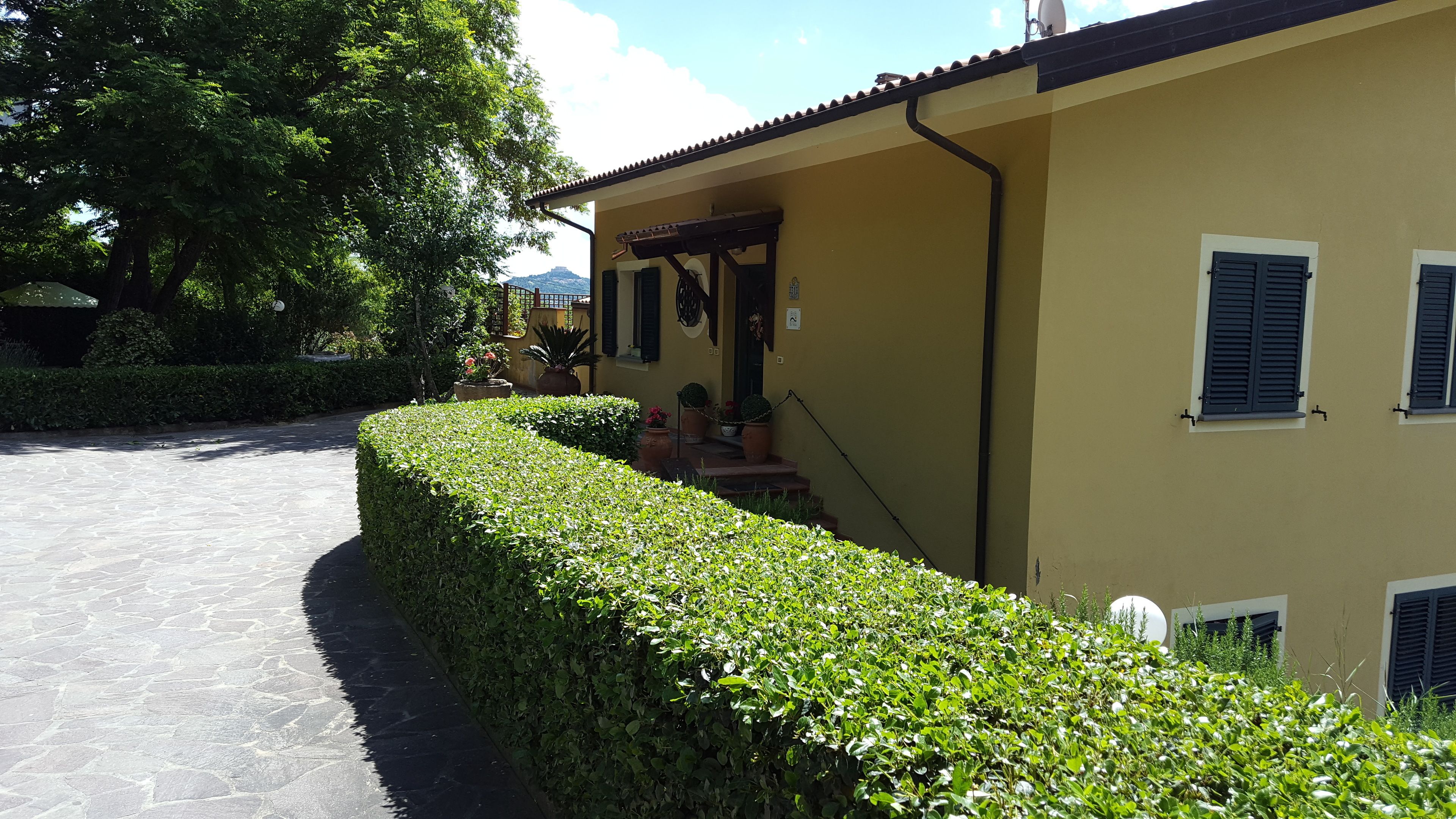 Un edificio giallo con un vialetto in pietra che conduce a una porta.