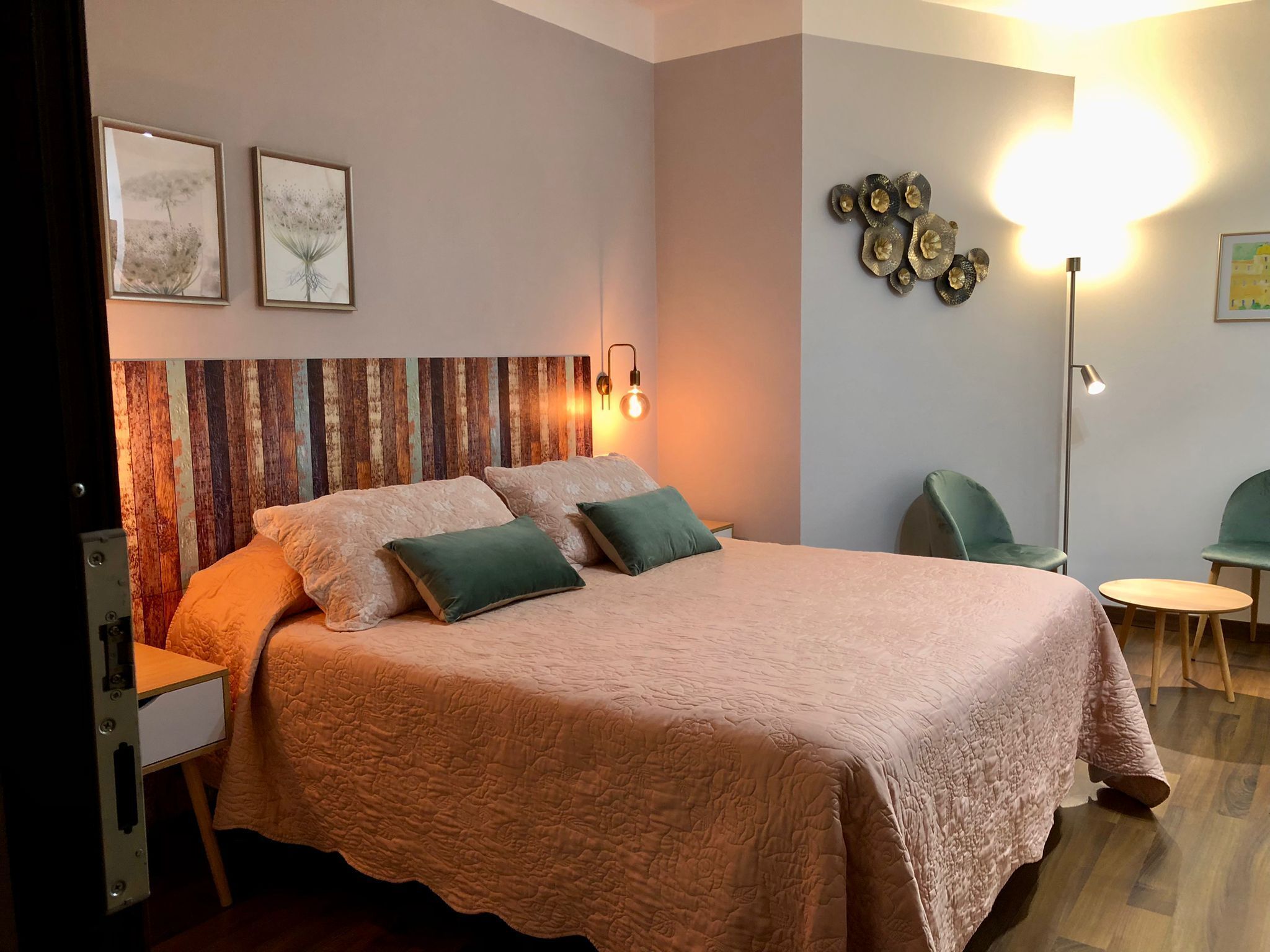 Ein Schlafzimmer mit einem Bett, zwei Kissen, einem Nachttisch, einer Lampe und einem Stuhl.
