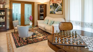 A living room with a chessboard, a sofa, a coffee table, and a patterned rug. - Bed & Breakfast La Valle (Talamello)