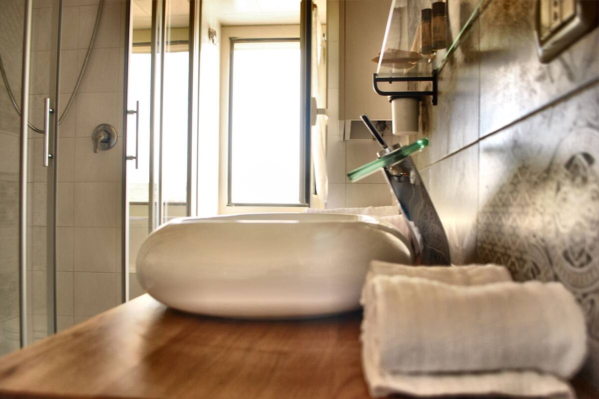 A bathroom with a white sink, a wooden countertop, and a towel.