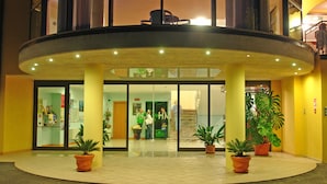 A hotel entrance with a glass door, potted plants, and a staircase leading to the upper floor. - Hotel Mercedes (Limone sul Garda)