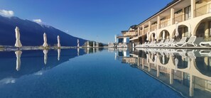 Una piscina al aire libre de temporada, sombrillas